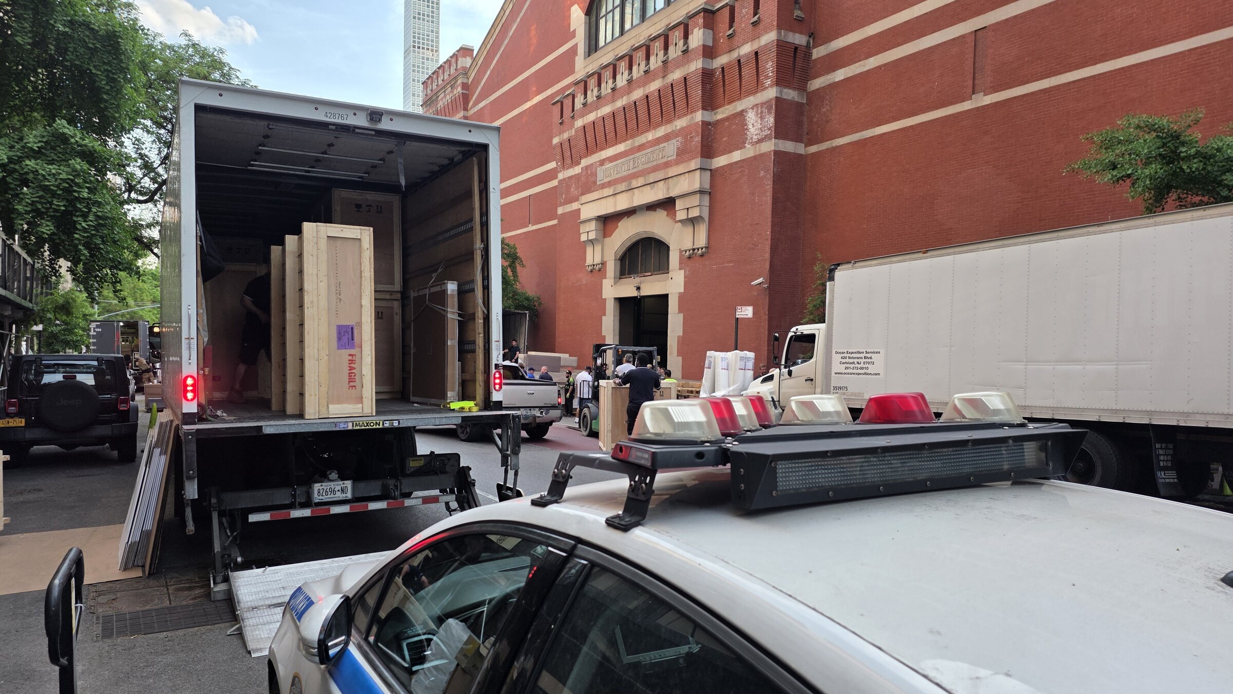 Fine-art trucks and wooden crates at the Lexington Avenue service side of Park Avenue Armory during TEFAF New York 2026